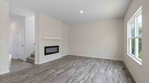 Living room beside kitchen, with electric fireplace and large window