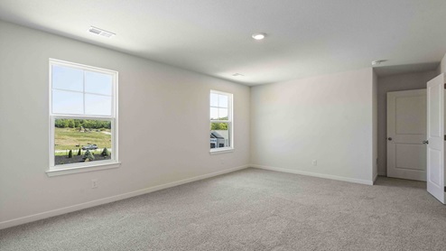 Primary bedroom with carpet, and two large windows