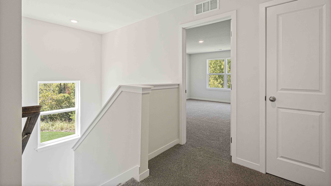 Upstairs hallway with carpet and large window