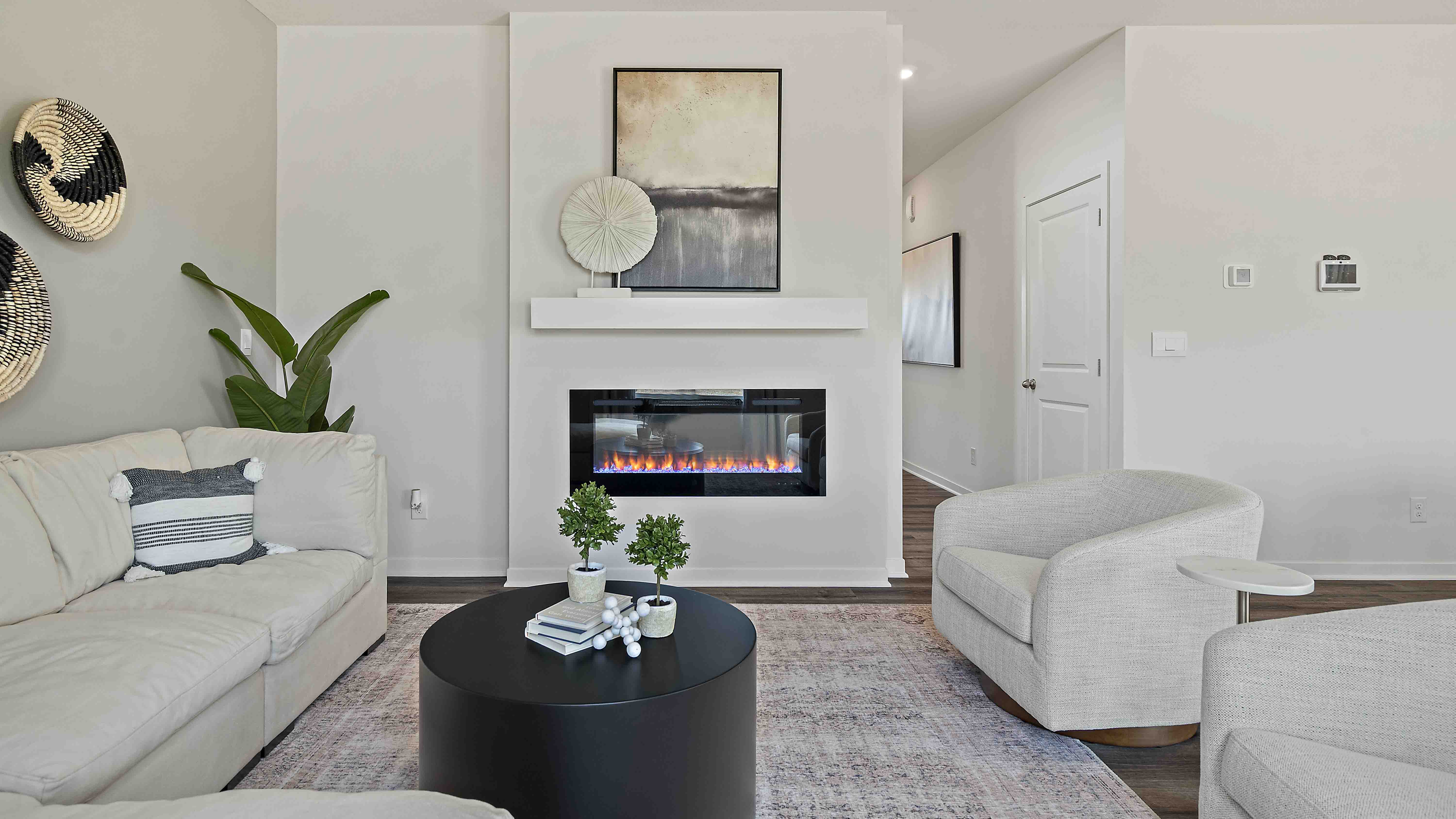 Living room beside kitchen, with electric fireplace and large window