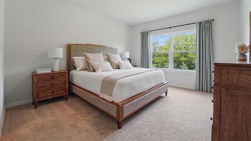 bedroom with beige carpet, grey walls and a window