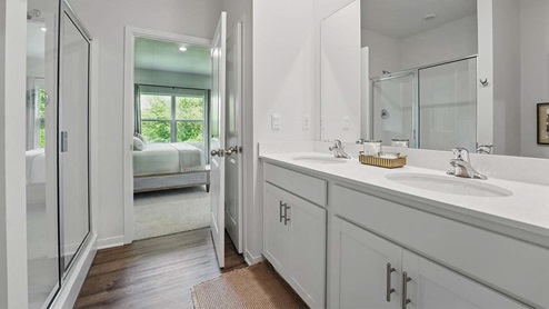 bathroom with dual vanity sinks, toilet, and a walk in shower