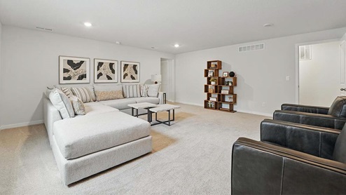 finished basement with beige carpet, grey walls and a window