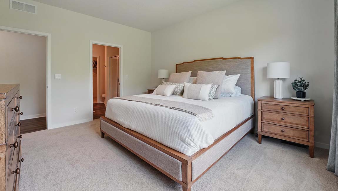 Carpeted primary bedroom with large windows