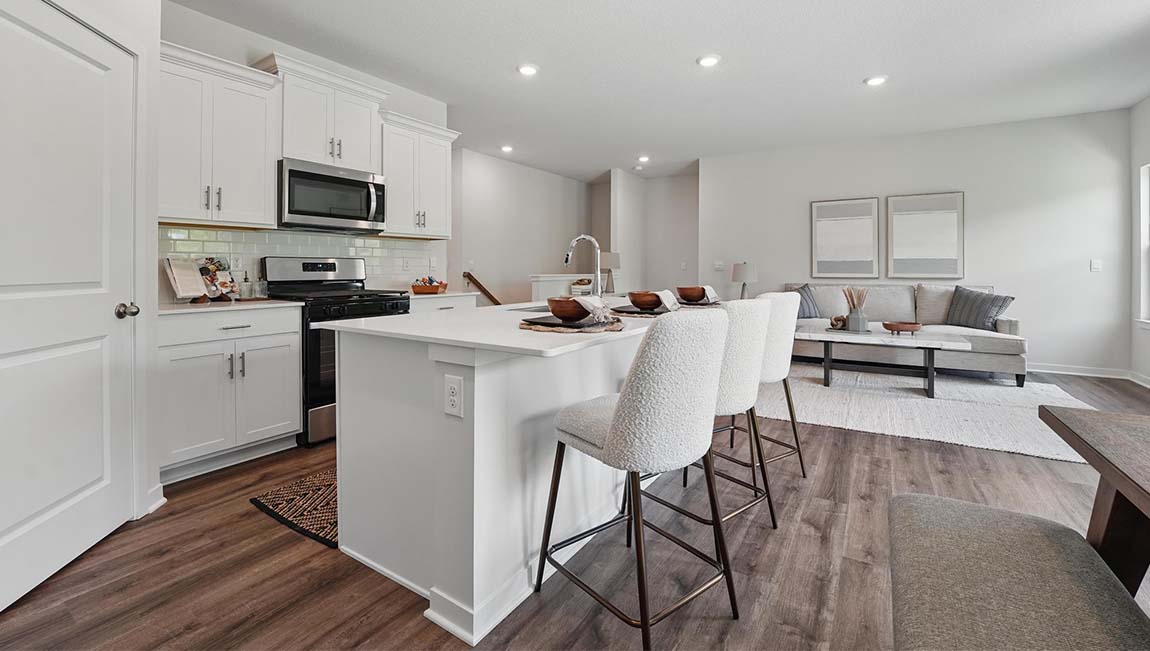 Open-concept kitchen with white counters and cabinets, and stainless steel appliances