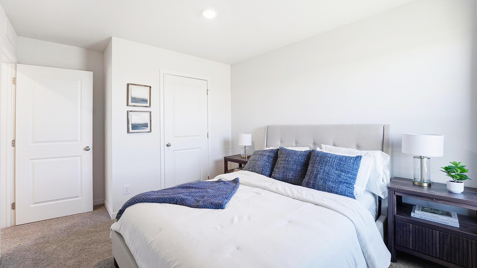 Carpeted bedroom with large window.