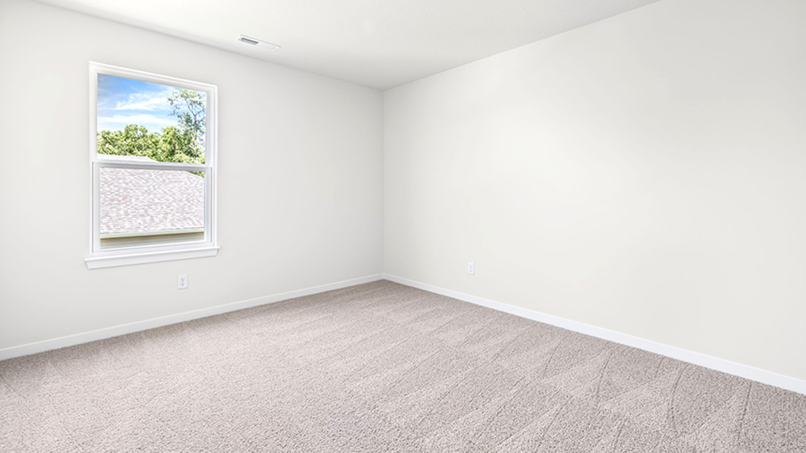 Carpeted bedroom with large window.