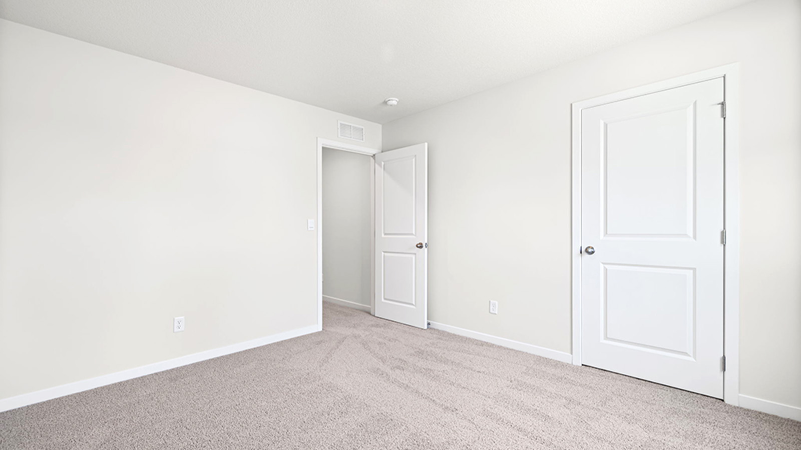 Carpeted bedroom with large window.