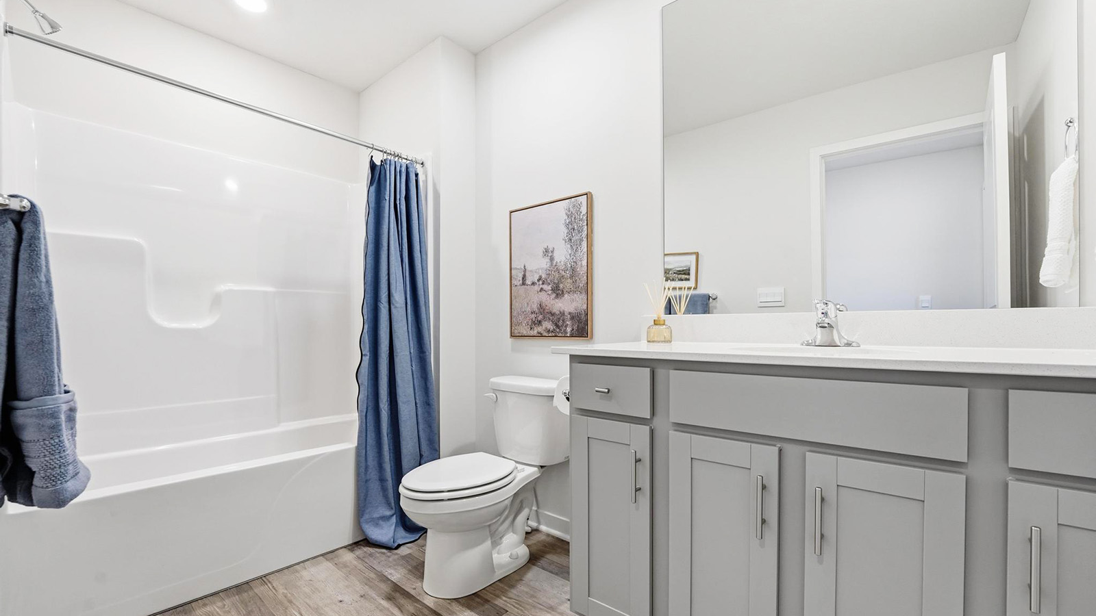 Primary bathroom with double sink vanity, white cabinets and glass door shower