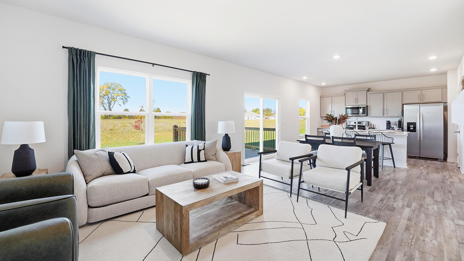 Living room beside kitchen, with electric fireplace and large window