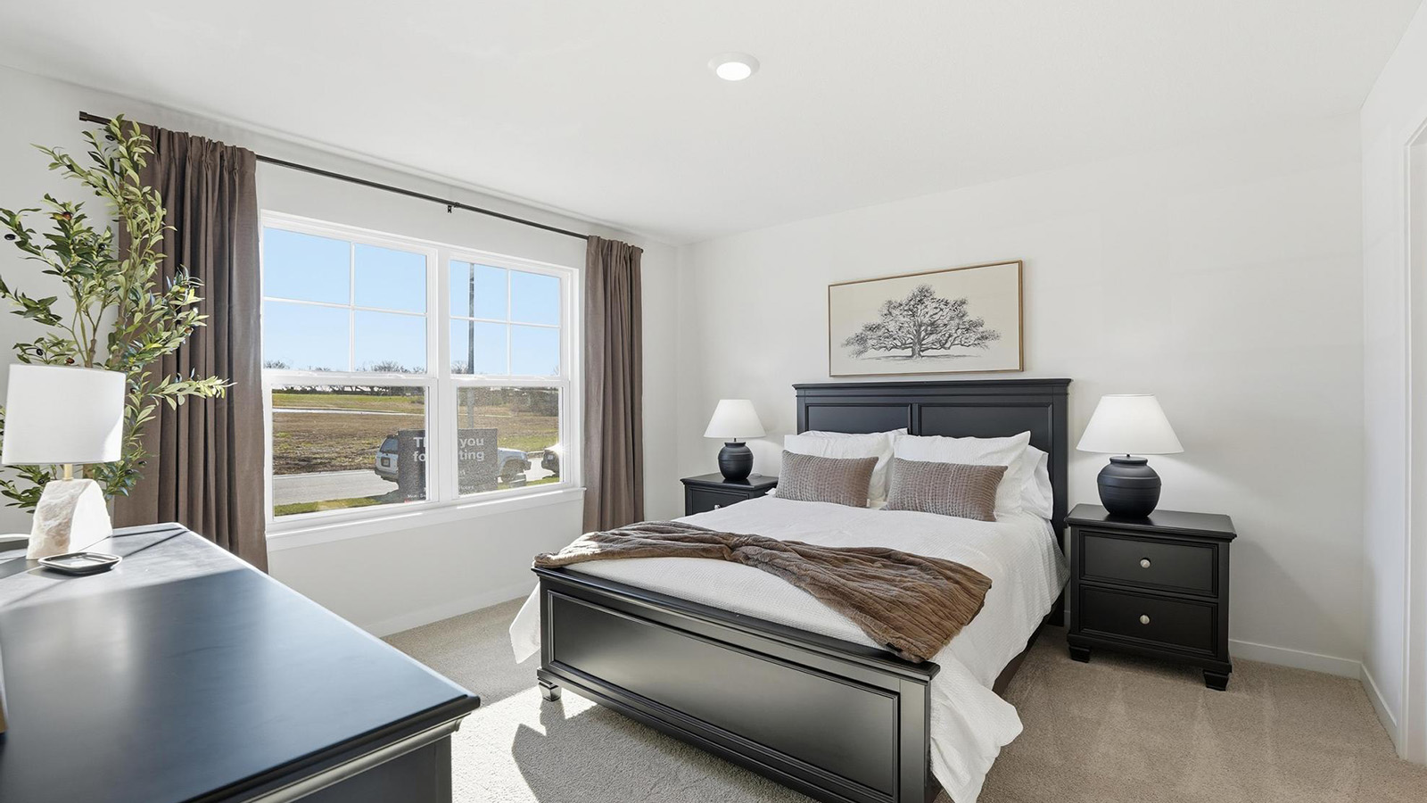 Carpeted primary bedroom with large windows