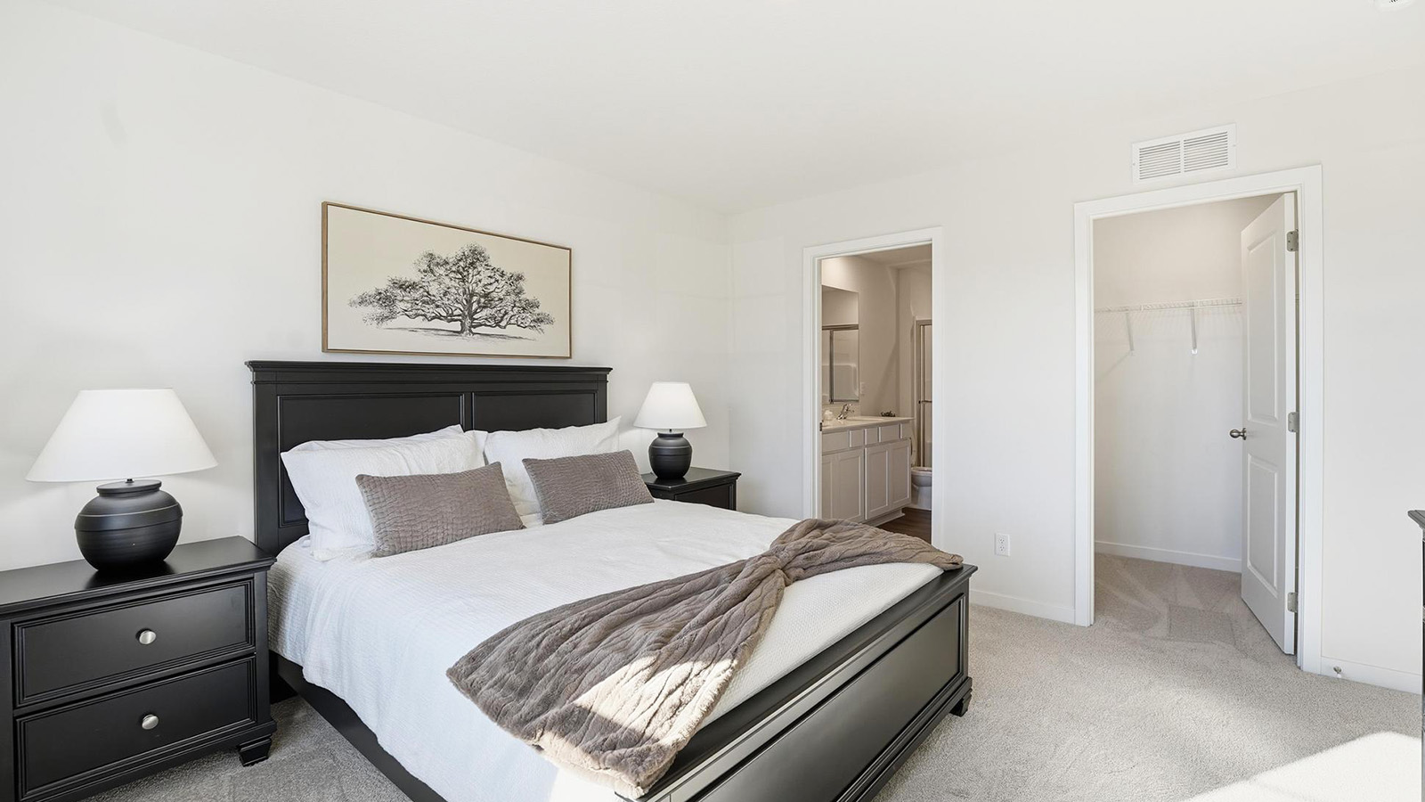 Carpeted primary bedroom with large windows