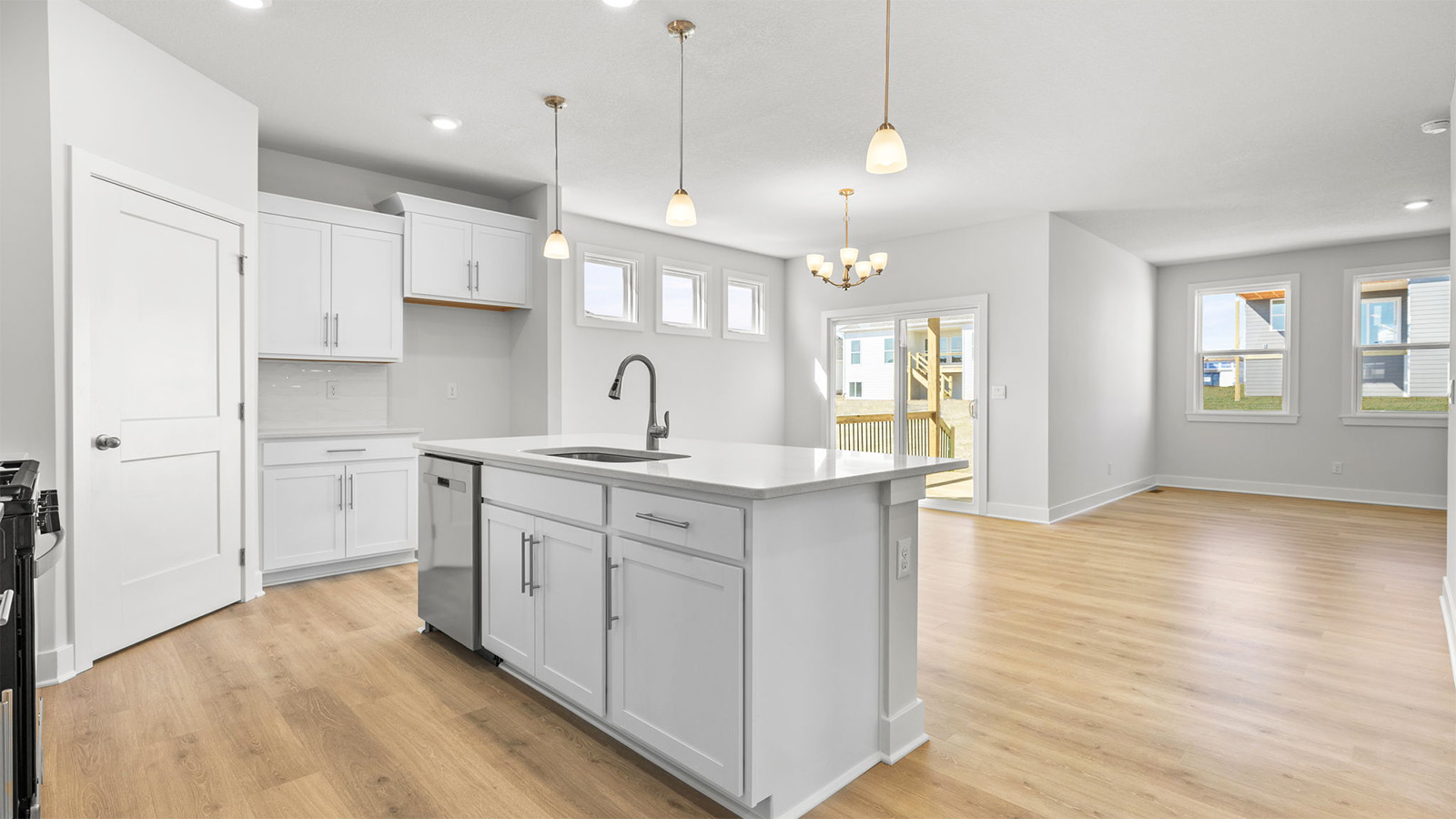 Kitchen and island with white cabinets, tile backsplash, and stainless steel appliances
