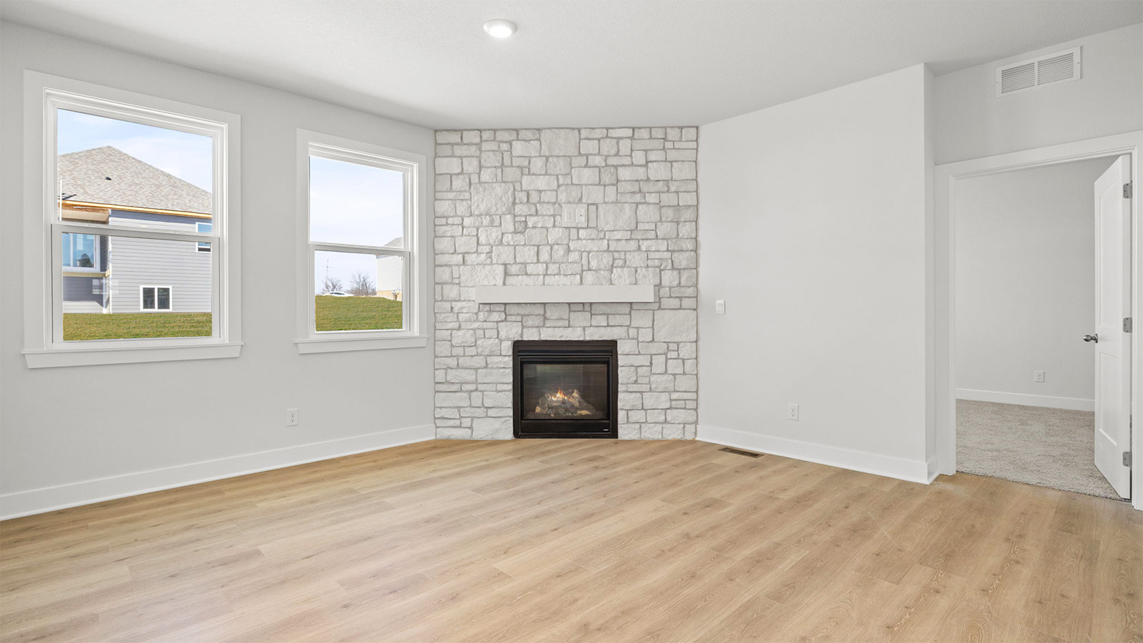 Living room beside kitchen, with stone fireplace and large window