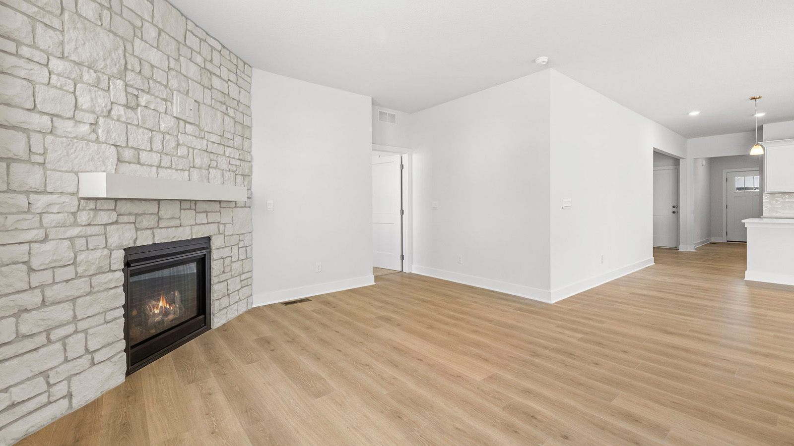 Living room beside kitchen, with stone fireplace and large window