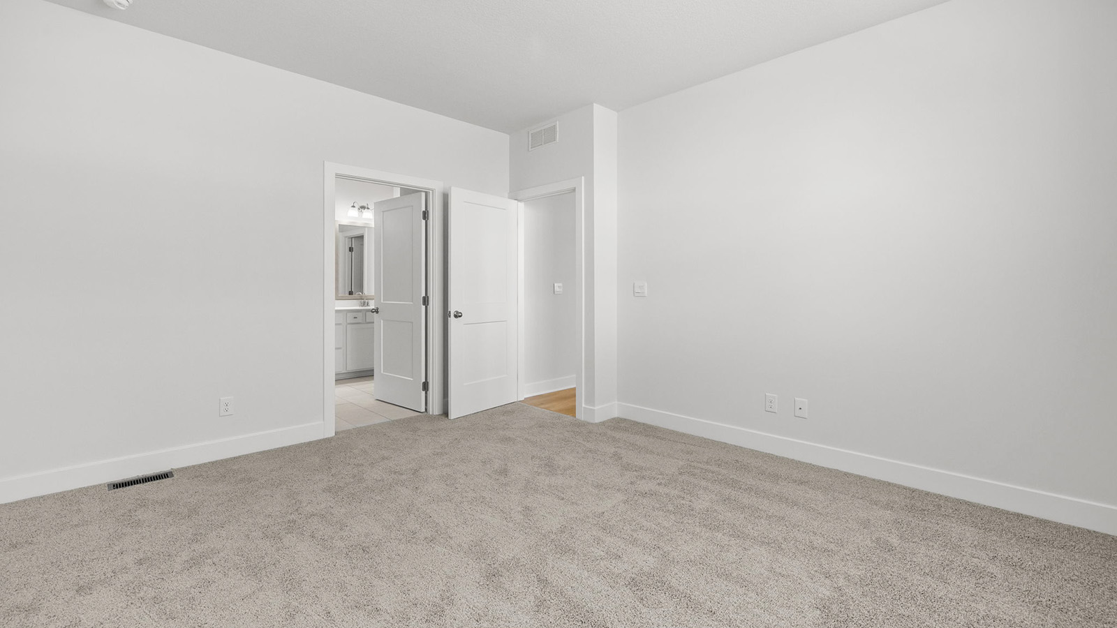 Primary bedroom with carpet, and two large windows