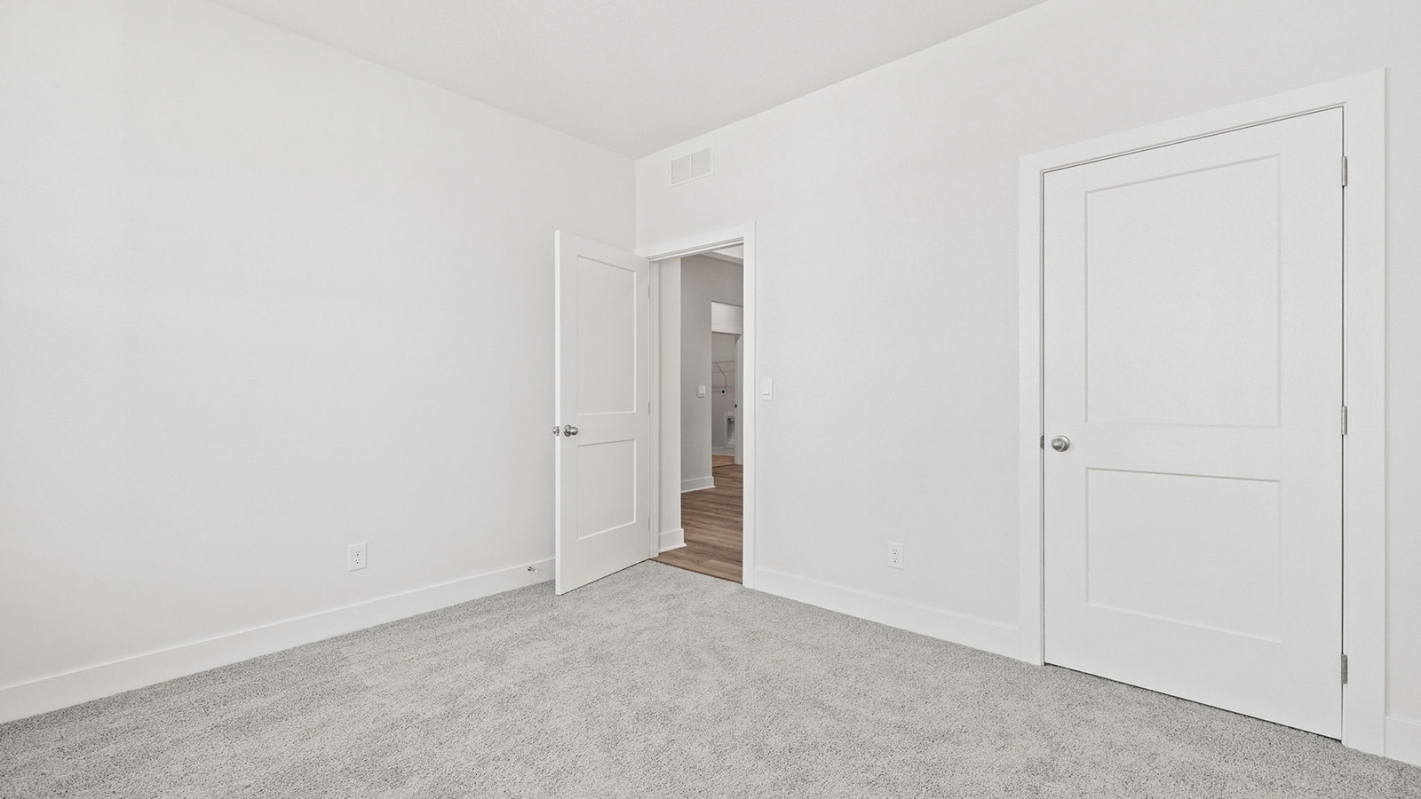 Carpeted bedroom with large windows