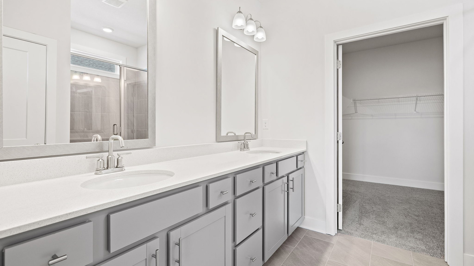 Primary bathroom with double vanity and glass shower