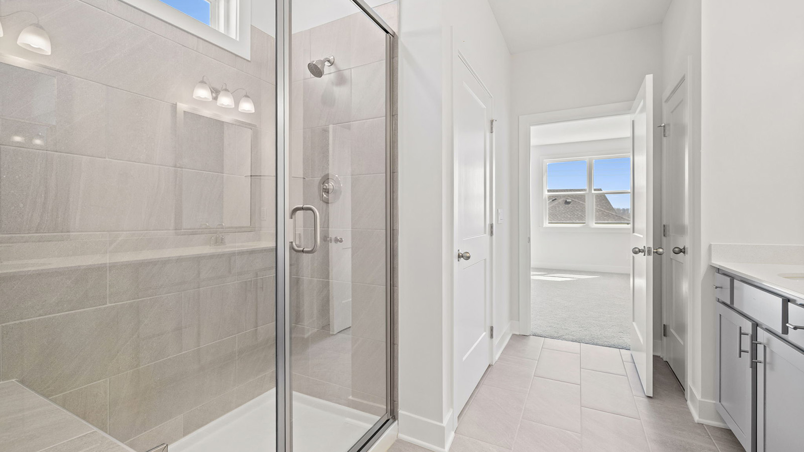 Primary bathroom with double vanity and glass shower