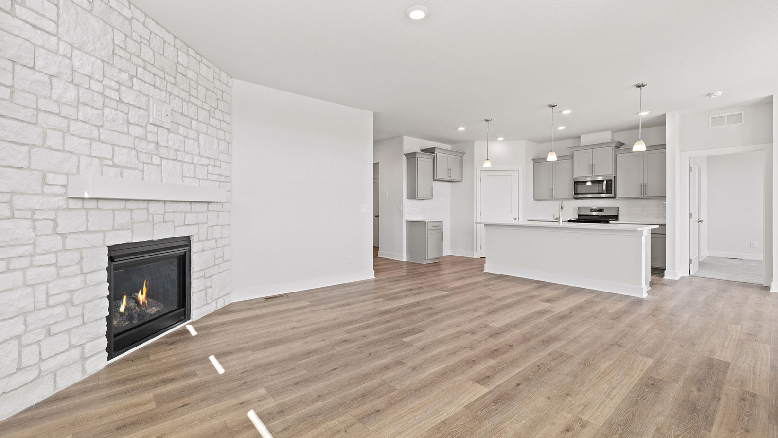 Living room beside kitchen, with stone fireplace and large windows