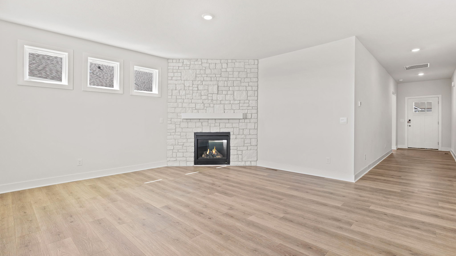 Living room beside kitchen, with stone fireplace and large windows