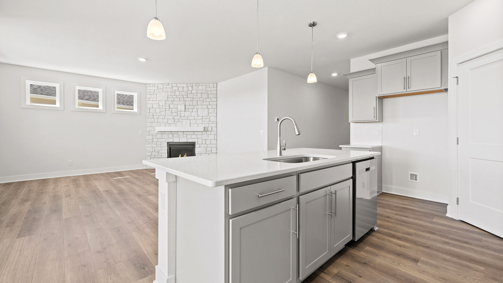 Kitchen and island with white cabinets, tile backsplash, and stainless steel appliances