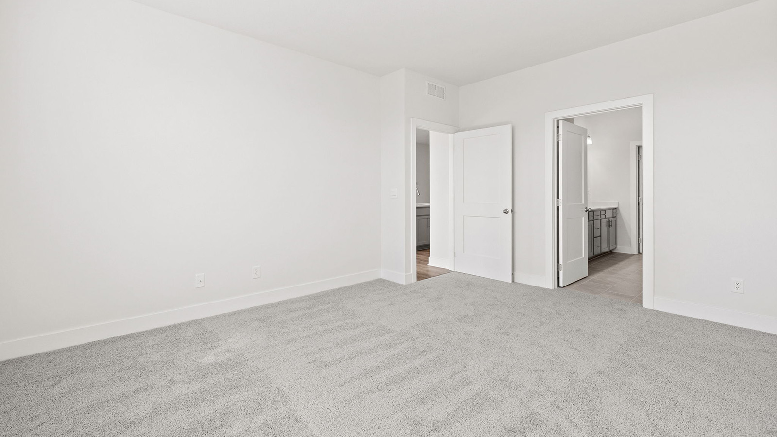 Primary bedroom with carpet, and two large windows