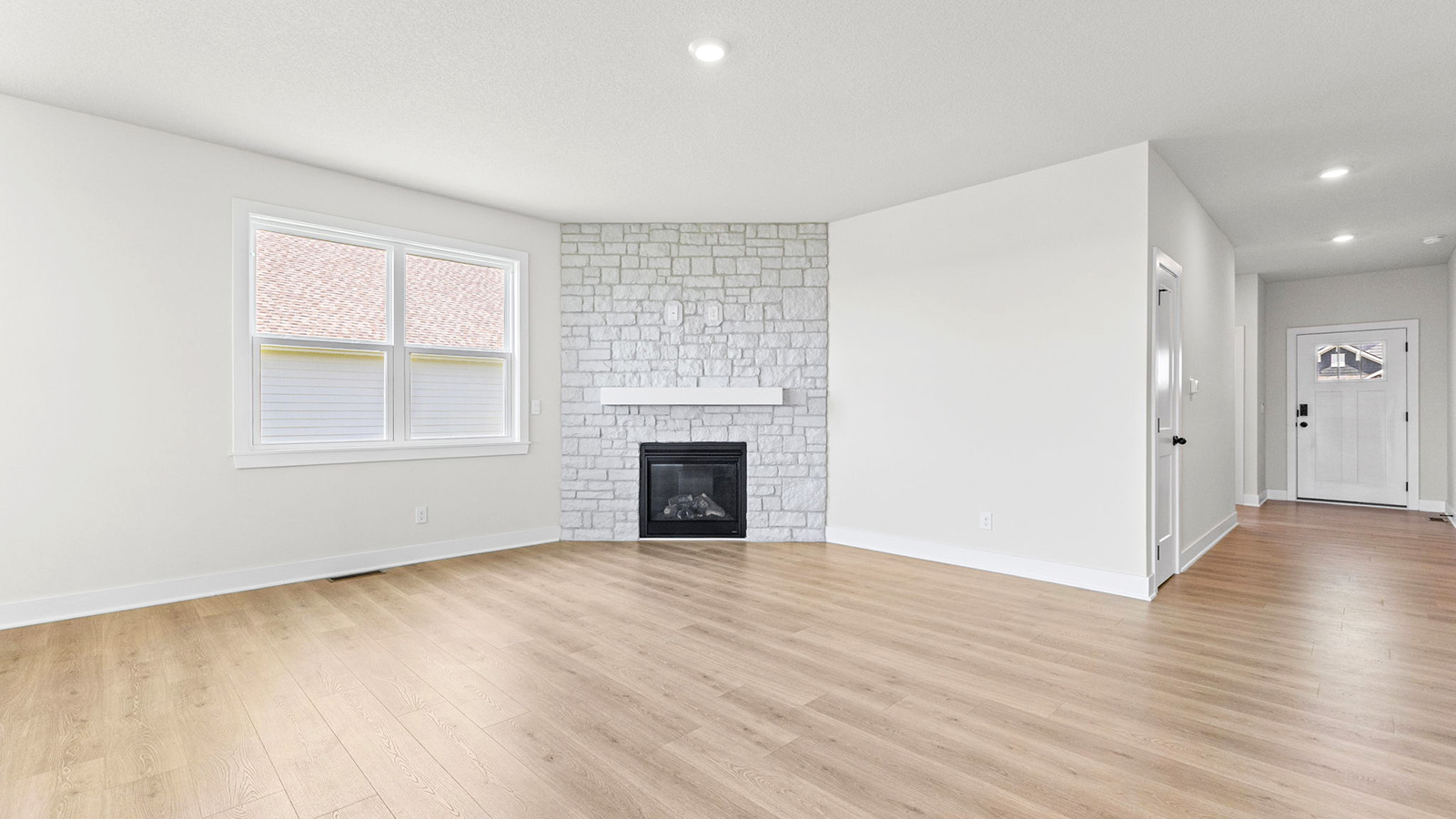 Living room beside kitchen, with stone fireplace and large window