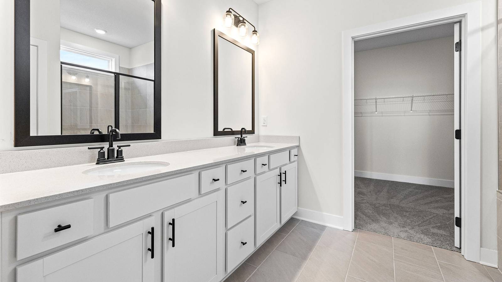 Primary bathroom with double vanity and shower with glass door