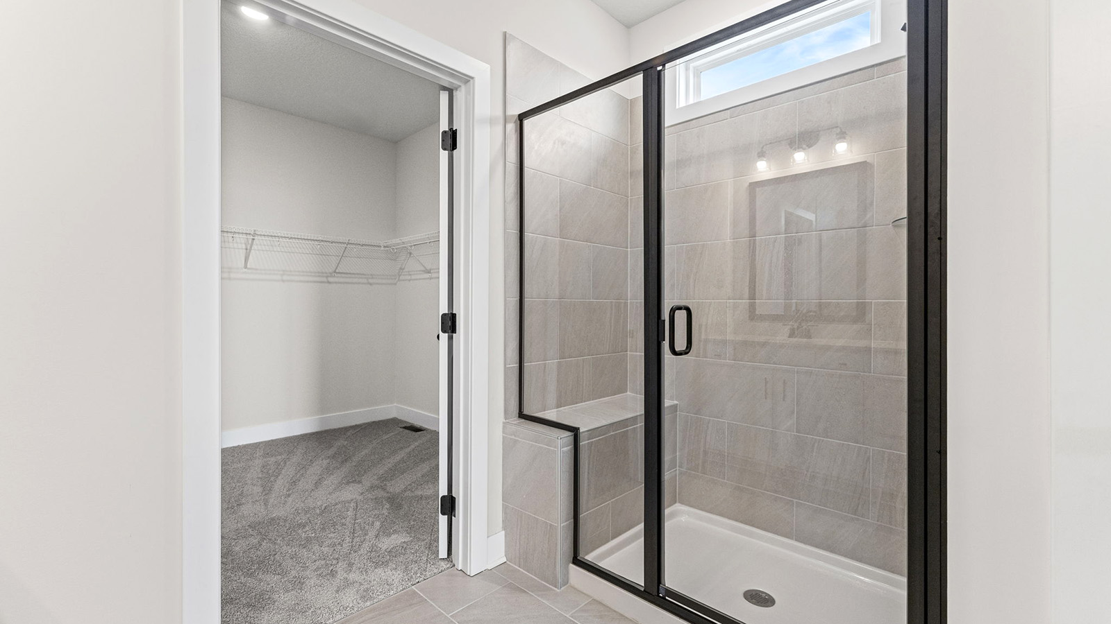 Primary bathroom with double vanity and shower with glass door