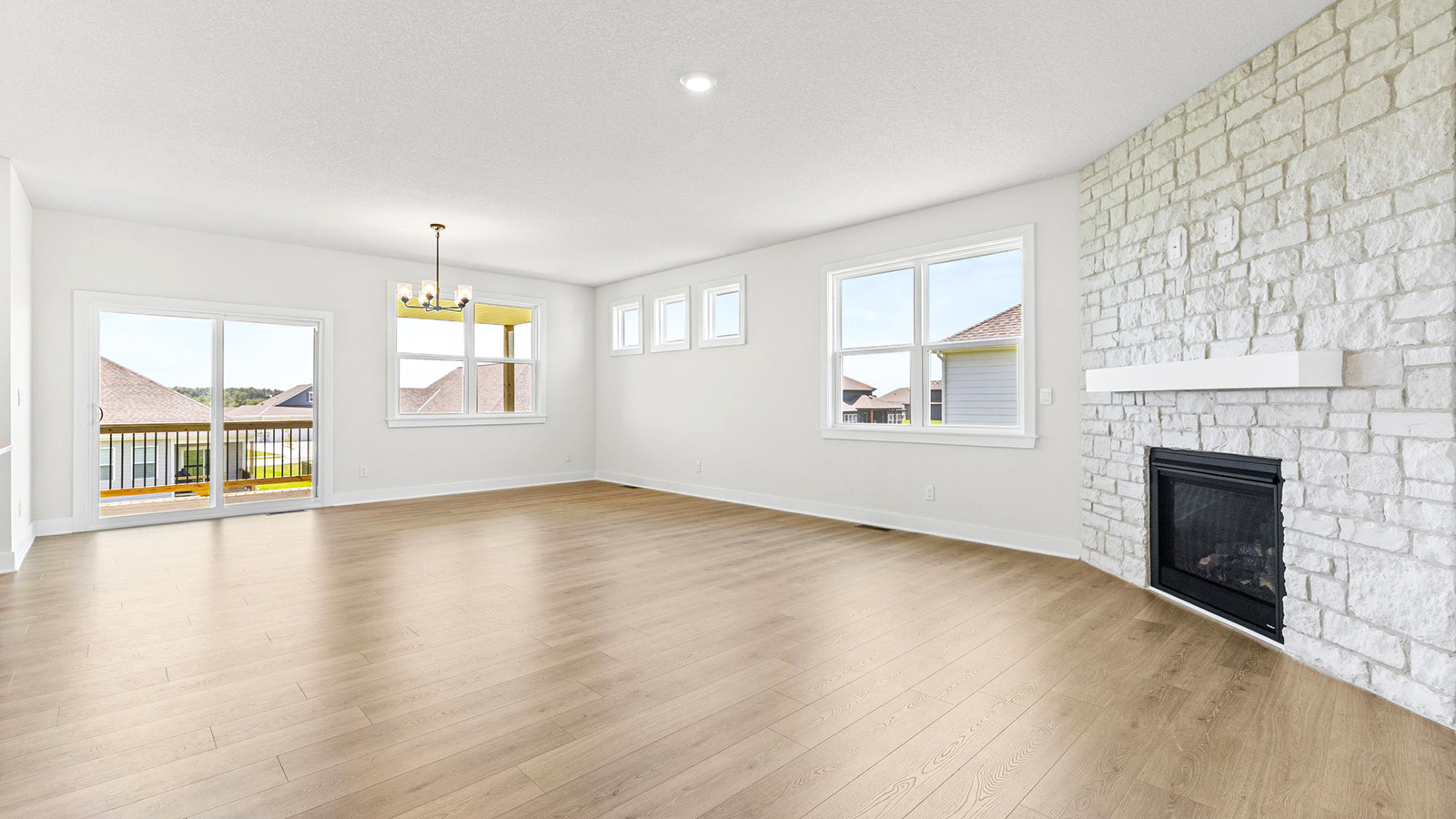 Living room beside kitchen, with stone fireplace and large window