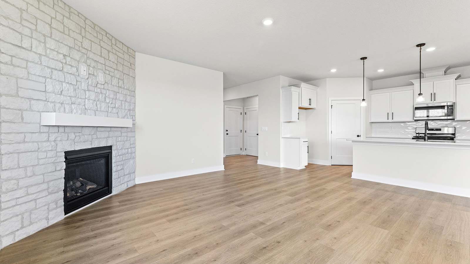 Living room beside kitchen, with stone fireplace and large window