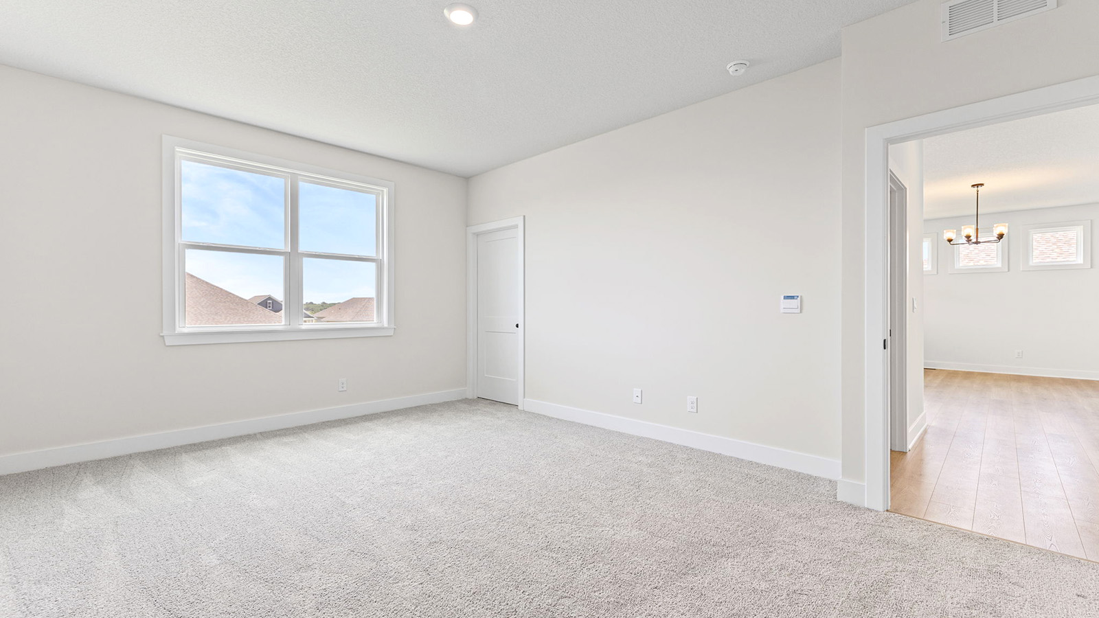 Primary bedroom with carpet, and two large windows