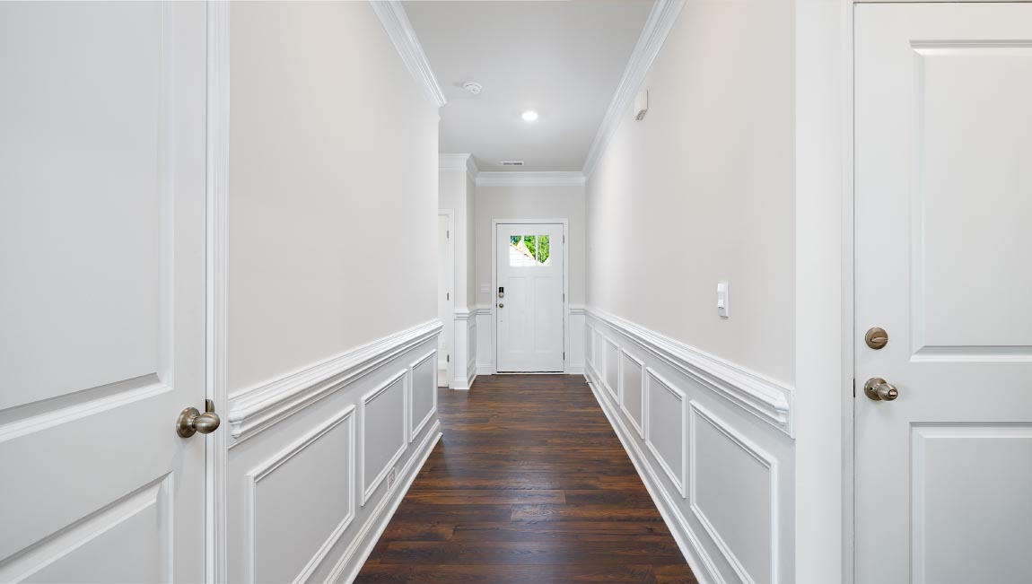 Welcoming foyer with wood floors, view of french doors, front door and staircase
