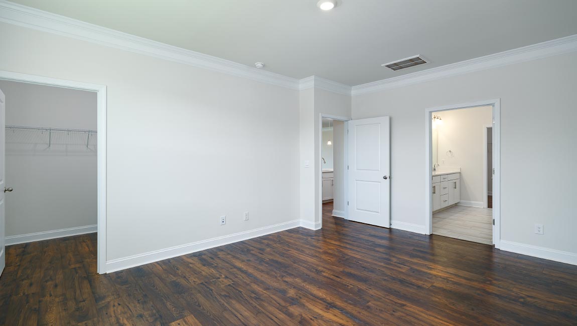 Primary bedroom with wood floors, and large window