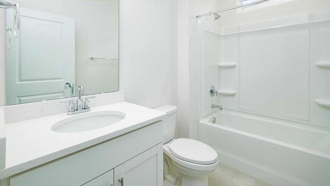 Bathroom with bathtub and white cabinets