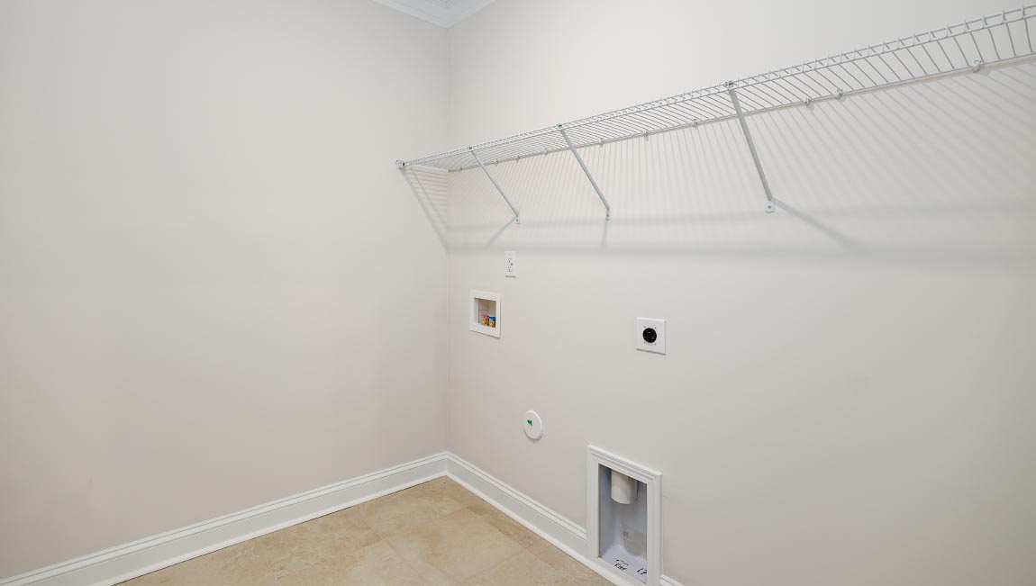 Laundry room with racks for storage and a sink with white cabinets