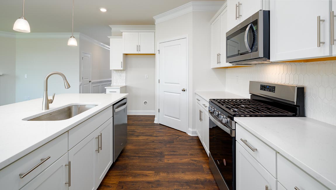 Kitchen and island with wood floors, white cabinets, breakfast area at island bar, and stainless steel appliances