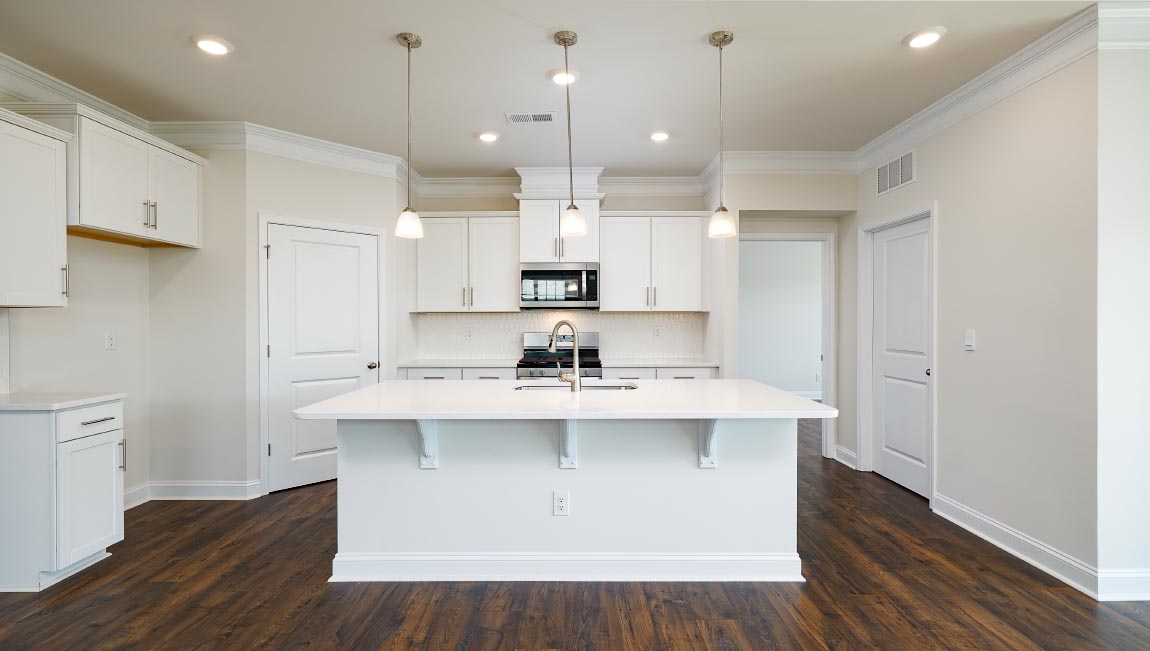 Kitchen and island with wood floors, white cabinets, breakfast area at island bar, and stainless steel appliances