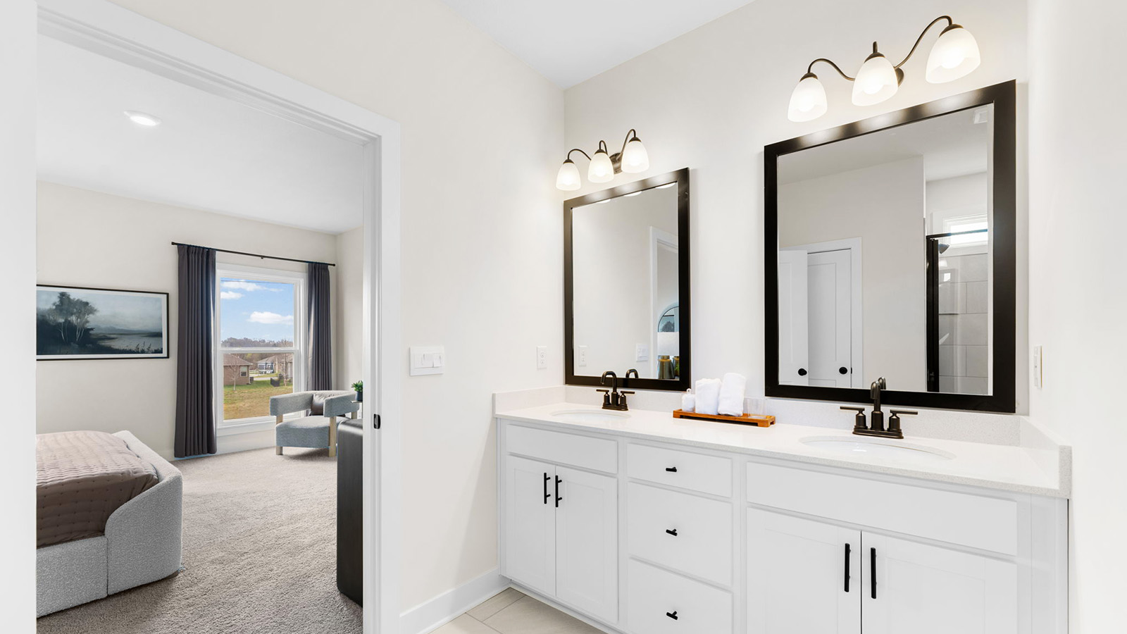 Primary bathroom with double vanity and shower with glass door