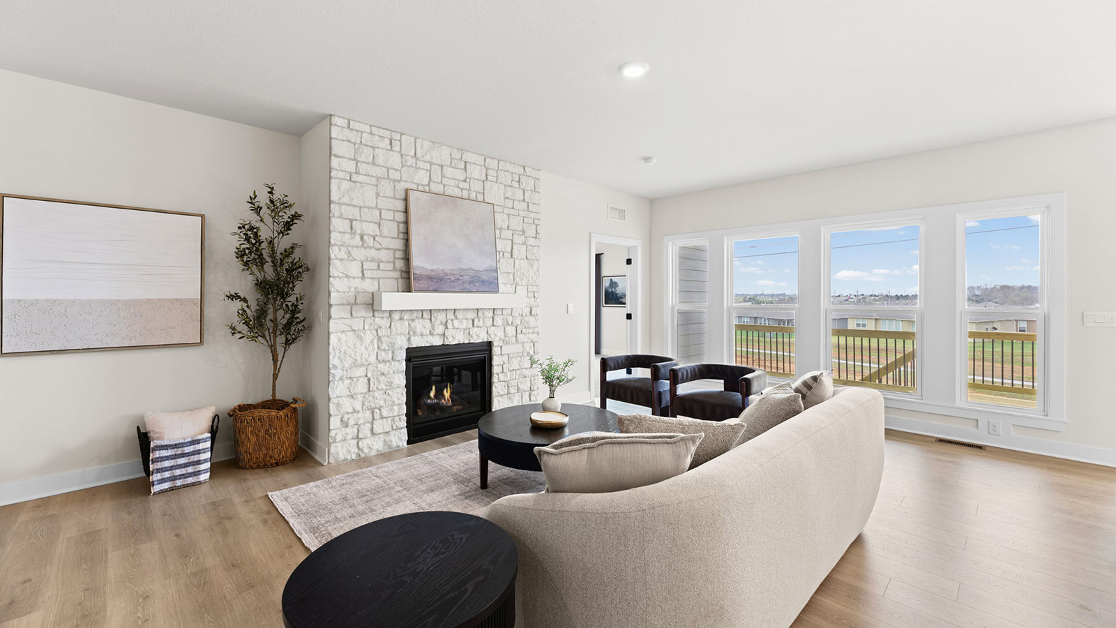 Living room beside kitchen, with electric fireplace and large window