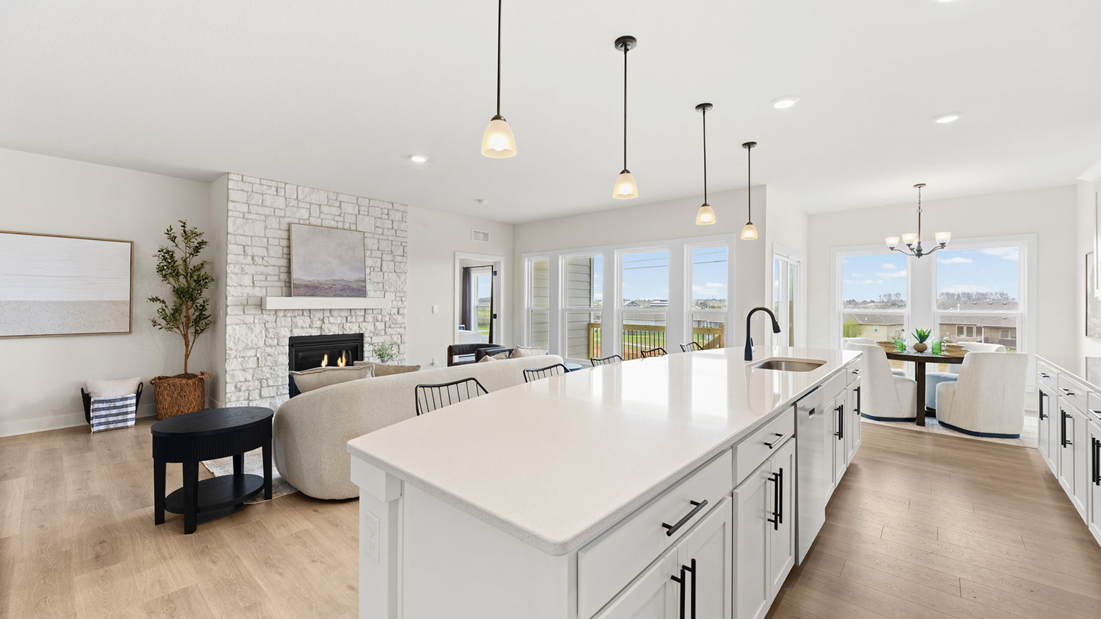 Kitchen and island with white cabinets, tile backsplash, and stainless steel appliances