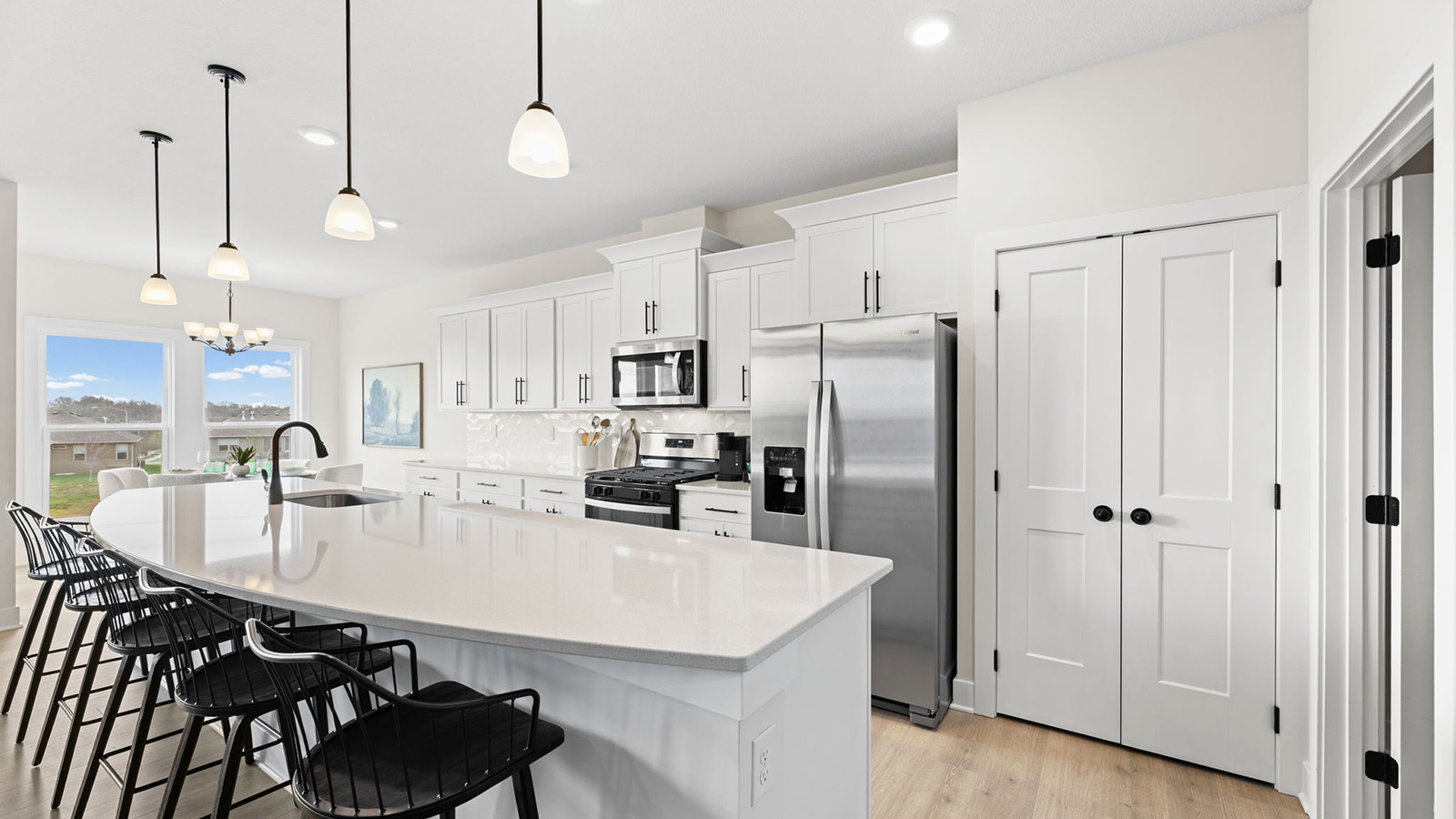 Kitchen and island with white cabinets, tile backsplash, and stainless steel appliances