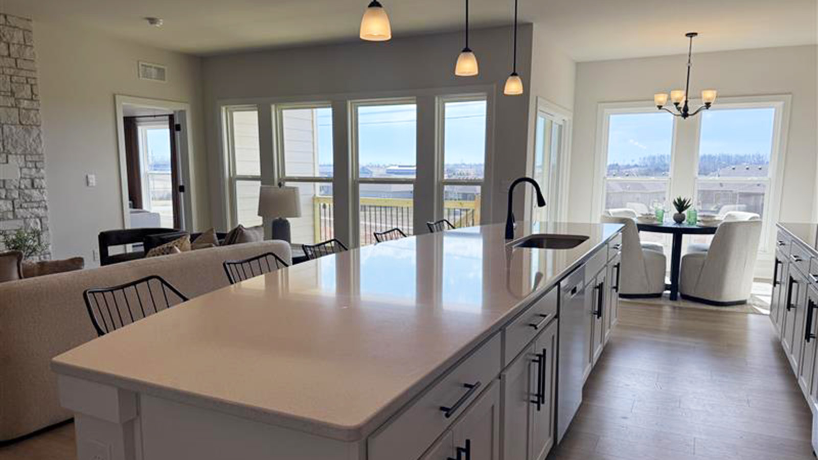 Kitchen with large island, quartz countertops, tile backsplash and stainless steel apliances