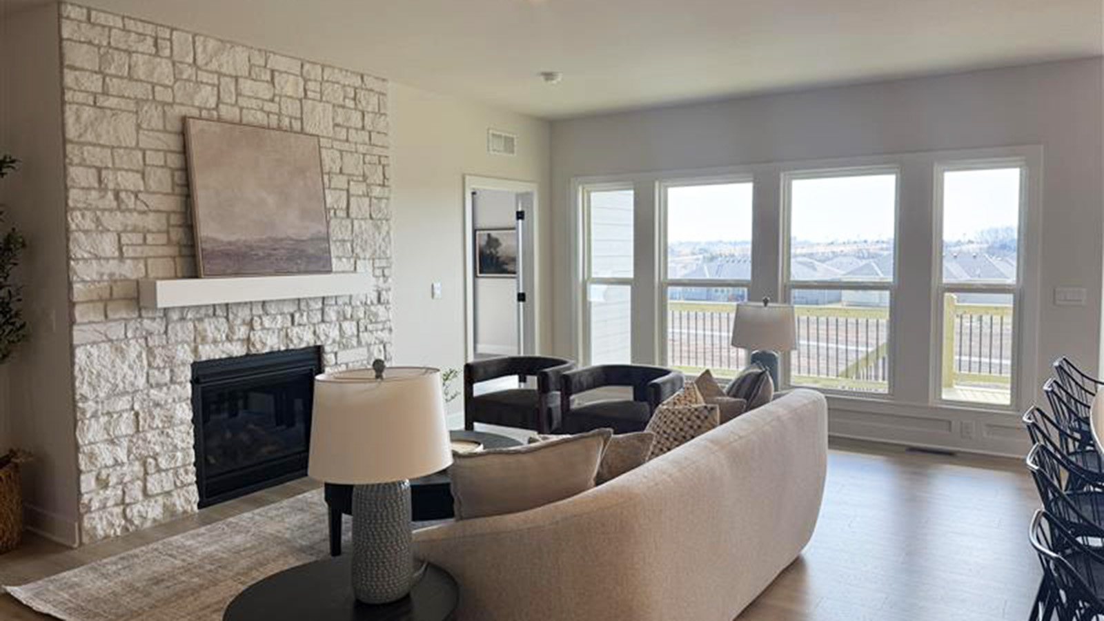 Living room with large windows and stone fireplace