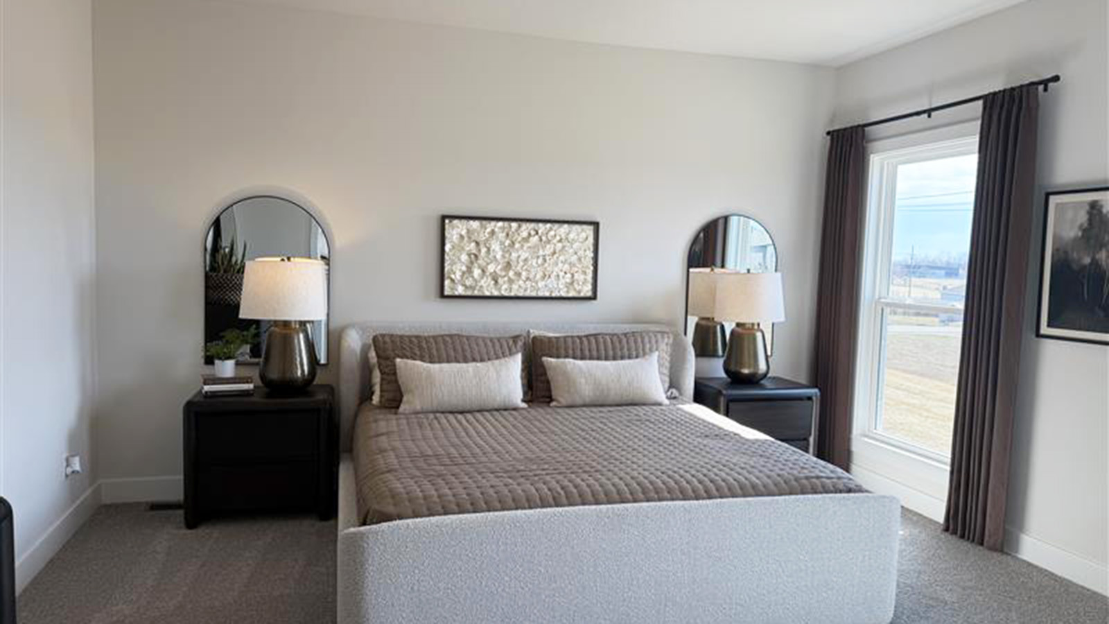 Carpeted primary bedroom with large windows