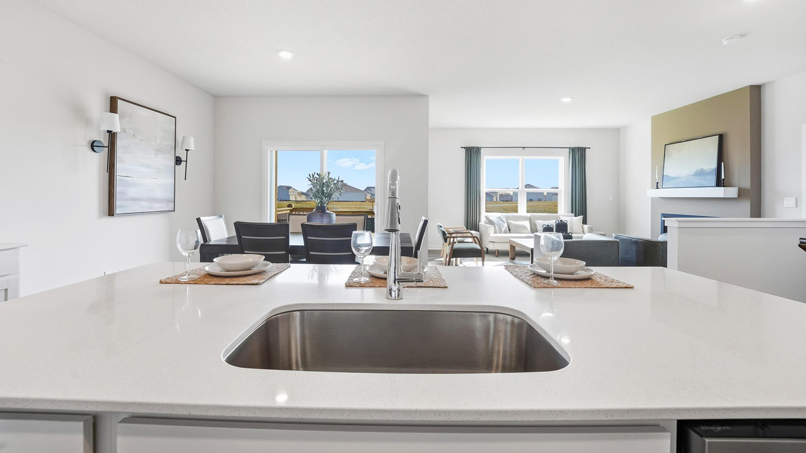 Kitchen and island with white cabinets, tile backsplash, and stainless steel appliances