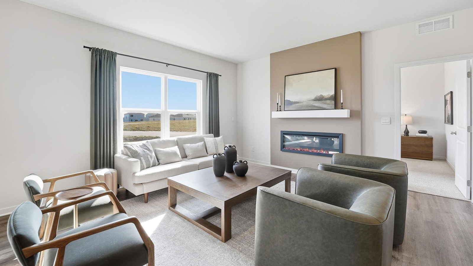 Living room beside kitchen, with electric fireplace and large window