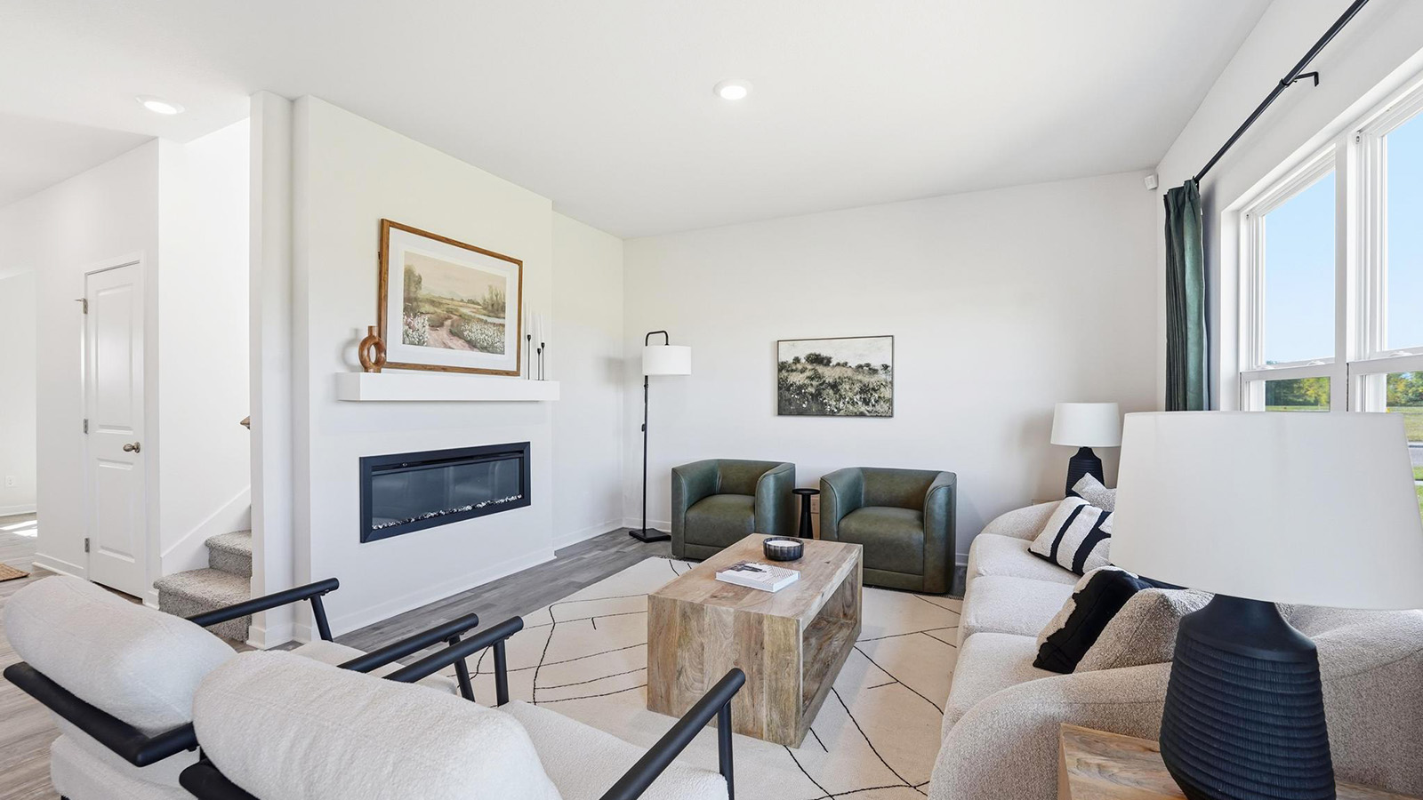 Living room with electric fireplace and large windows.