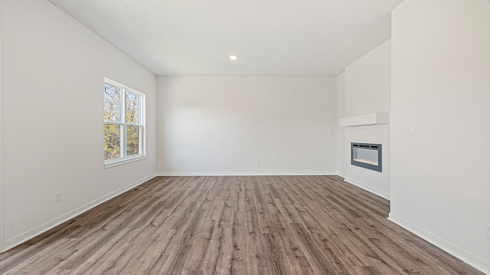 Open concept living area with electric fireplace and large window
